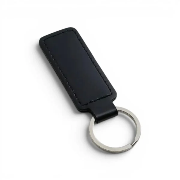 A black, blank premium leather keyholder before customisation, showcasing the raw stitching and thick leather grain on a wooden workshop table by WIKXY.