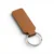 A coffe brown, blank premium leather keyholder before customisation, showcasing the raw stitching and thick leather grain on a wooden workshop table by WIKXY.