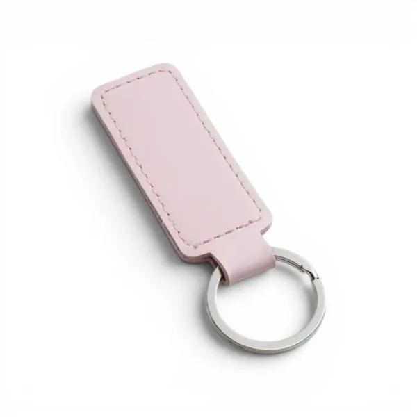 A pink colour, blank premium leather keyholder before customisation, showcasing the raw stitching and thick leather grain on a wooden workshop table by WIKXY.