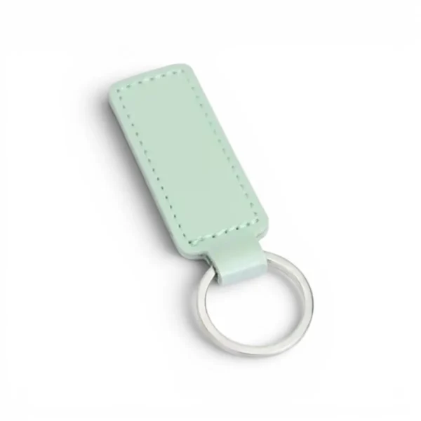 A mint green, blank premium leather keyholder before customisation, showcasing the raw stitching and thick leather grain on a wooden workshop table by WIKXY.