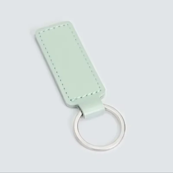laser-engraved-leather-keyholder-rectangular-shape-mint-green Pale green rectangular leather key fob with stitched edges and a silver metal ring